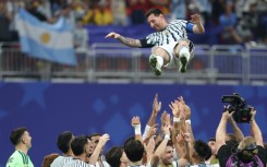 Argentina forward Lionel Messi is tossed into the air by team-mates after inspiring a late fightback in a 3-2 victory over Egypt