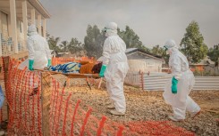 Healthcare workers carry a patient suffering from Ebola at a treatment centre in Bunia