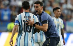 Argentina coach Lionel Scaloni speaks to Lionel Messi during their World Cup quarter-final against Switzerland in Kansas City