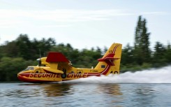 A firefighting plane scooped up water from the Seine river to douse the fire in Fontainebleau forest southeast of Paris