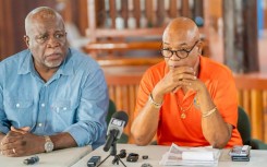 Guyana's Prime Minister Mark Phillips (L) and Minister of Public Works Juan Edghill (R) speak at a press conference after a ferry disaster
