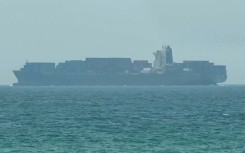 This frame grab taken from AFPTV video footage on July 12, 2026 shows a cargo ship anchoring near the Strait of Hormuz off the eastern coast of the United Arab Emirates at Khor Fakkan