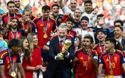 Spain's King Felipe VI (C) lifts the trophy next to Princess Leonor (2nd-L) and Princess Sofia (3rd-L) after winning the 2026 World Cup football tournament final match between Spain and Argentina at East Rutherford
