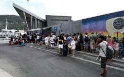 Visiting Turkish tourists line up to get their visa on arrival at the customs office in the village of Vathy on Greece's Samos island