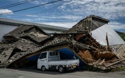 A house is seen collapsed onto a car in Yatsushiro, Kumamoto prefecture