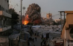 Palestinians run for cover as smoke and fire rise during an Israeli strike on the the Al-Muttaqin Mosque in Gaza City on July 28, 2026