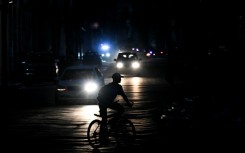 A man rides his bicycle down a street during a blackout in Havana