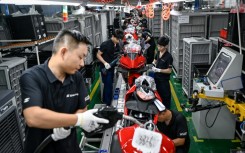 Workers assemble motorcycles at the ZXMoto factory in Chongqing, southwestern China