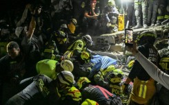 Firefighters and rescue teams carry survivor Daniela Largo from the rubble of a collapsed building after an earthquake in Pereira, Colombia