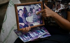Marlene Nino points to an old photo of her sister Doris, who was killed when her building collapsed in the 7.4 magnitude earthquake in Cali, Colombia