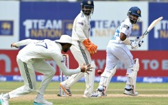 Sri Lanka's Sonal Dinusha (R) watches the ball after playing a shot during the third day of the first Test