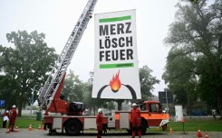 Greenpeace activists near the cabinet retreat set up a fire engine with a banner demanding: 'Merz, extinguish the fire'