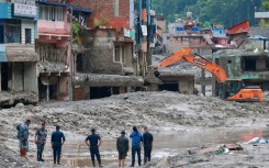 Workers use excavators to clear the mud at the Dhunge Bazaar in Nepal's Nuwakot district on August 29, 2026