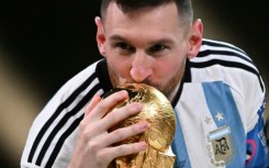 Lionel Messi kisses the World Cup trophy after winning the 2022 final against France in Doha