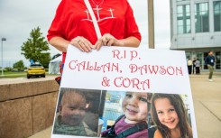 A woman carries a sign to show support for the three children of Lindsay Clancy during her murder trial in Plymouth, Massachusetts
