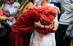 People mourn their missing relatives in the aftermath of flash floods, outside a mortuary in Nepal's Chitwan district