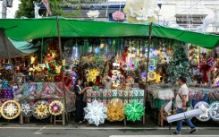 A man walks past Christmas decorations at a market in Quezon City, Metro Manila