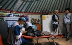 A dentist checks a child's teeth at a mobile dental clinic inside a traditional Mongolian ger in Ulaanbaatar