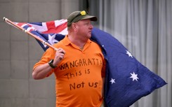 A man holds an Australian flag outside the office of Australian politician Helen Haines on October 20, 2026. The independent lawmaker Haines underwent surgery after an attack