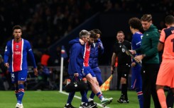 Khvicha Kvaratskhelia is helped off the pitch during PSG's game against Barcelona on Tuesday
